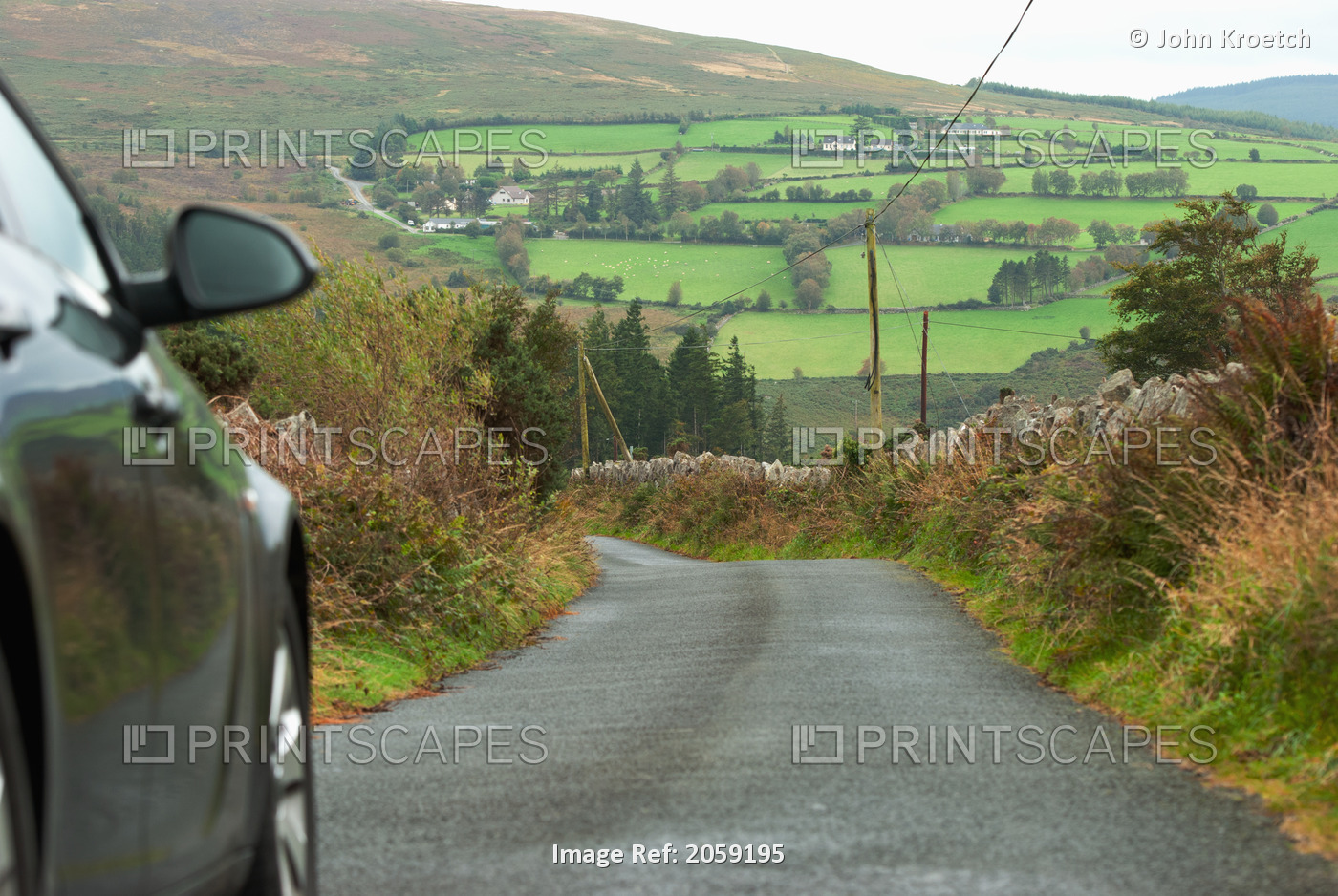A Car Travels Down A Paved Road; Ireland