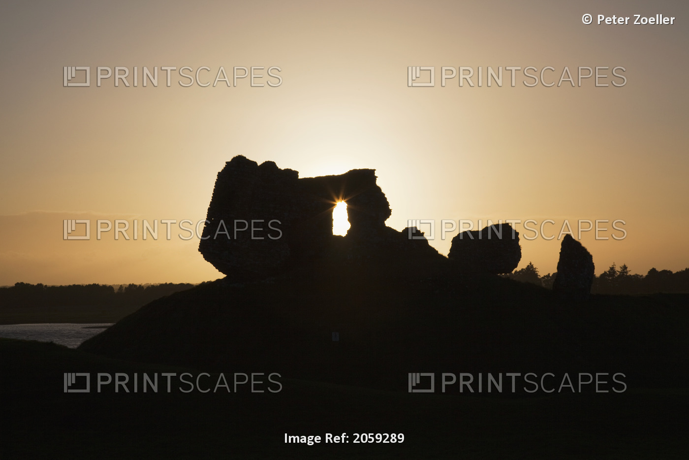 Sunlight Shining Through A Hole In A Rock Formation At Sunset; Clonmacnoise, ...