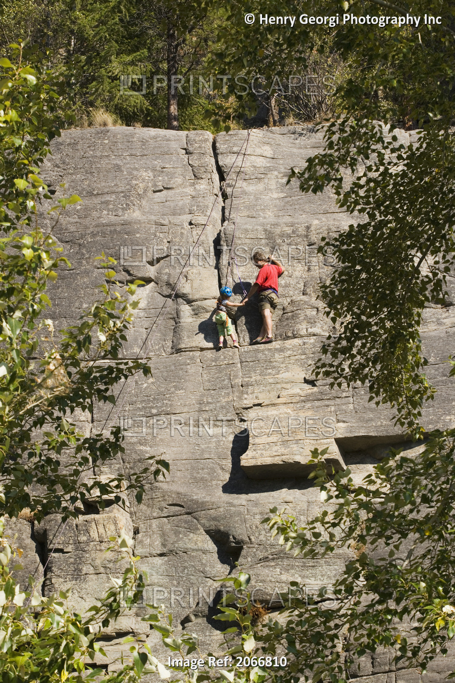 Mid-Aged Man Helping Daughter Tie Climbing Rope At Base Of Cliff, Near Rexford, ...