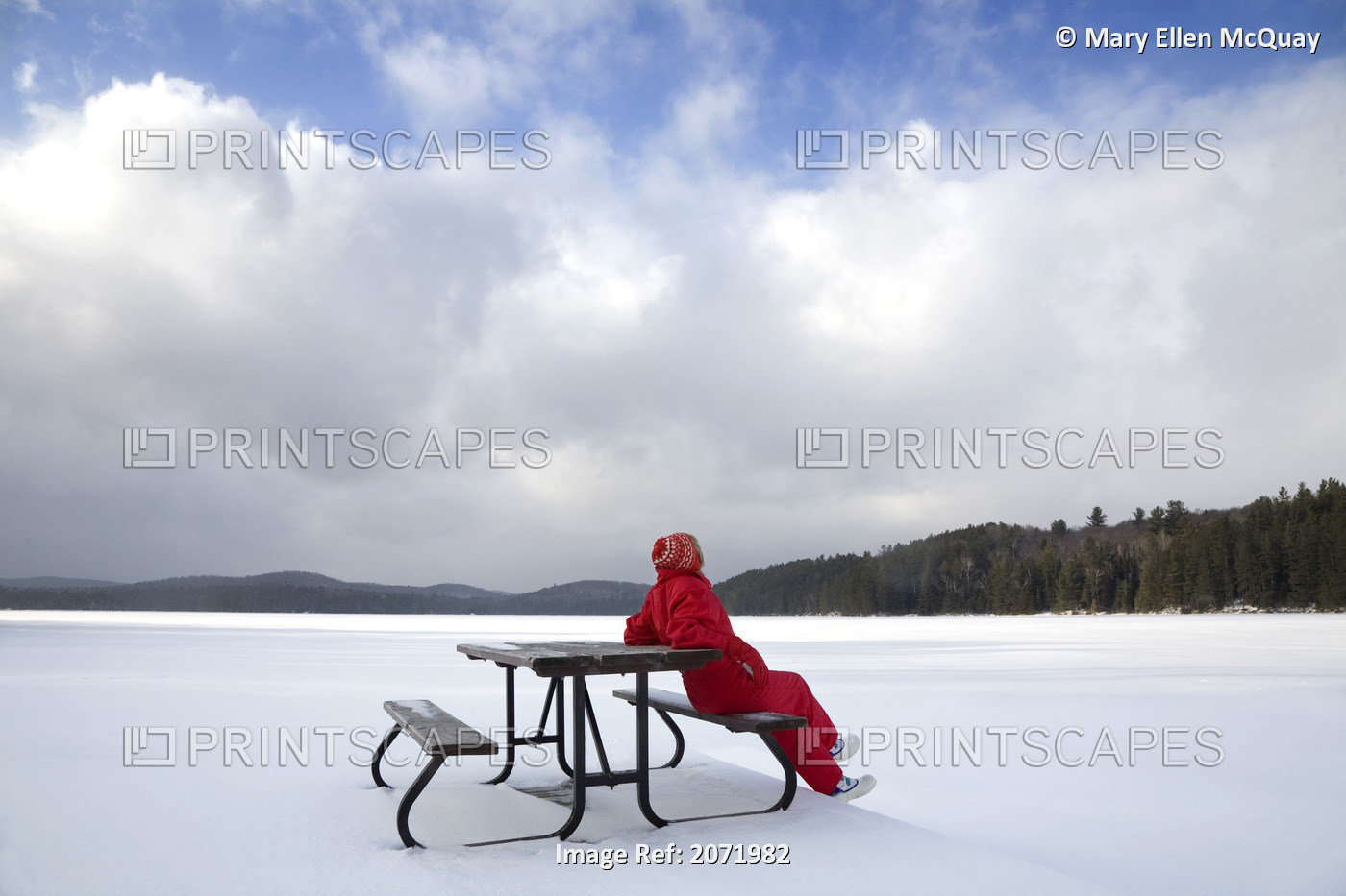 Senior Woman Sitting On A Picnic Table In Snow By A Frozen Lake, Algonquin ...