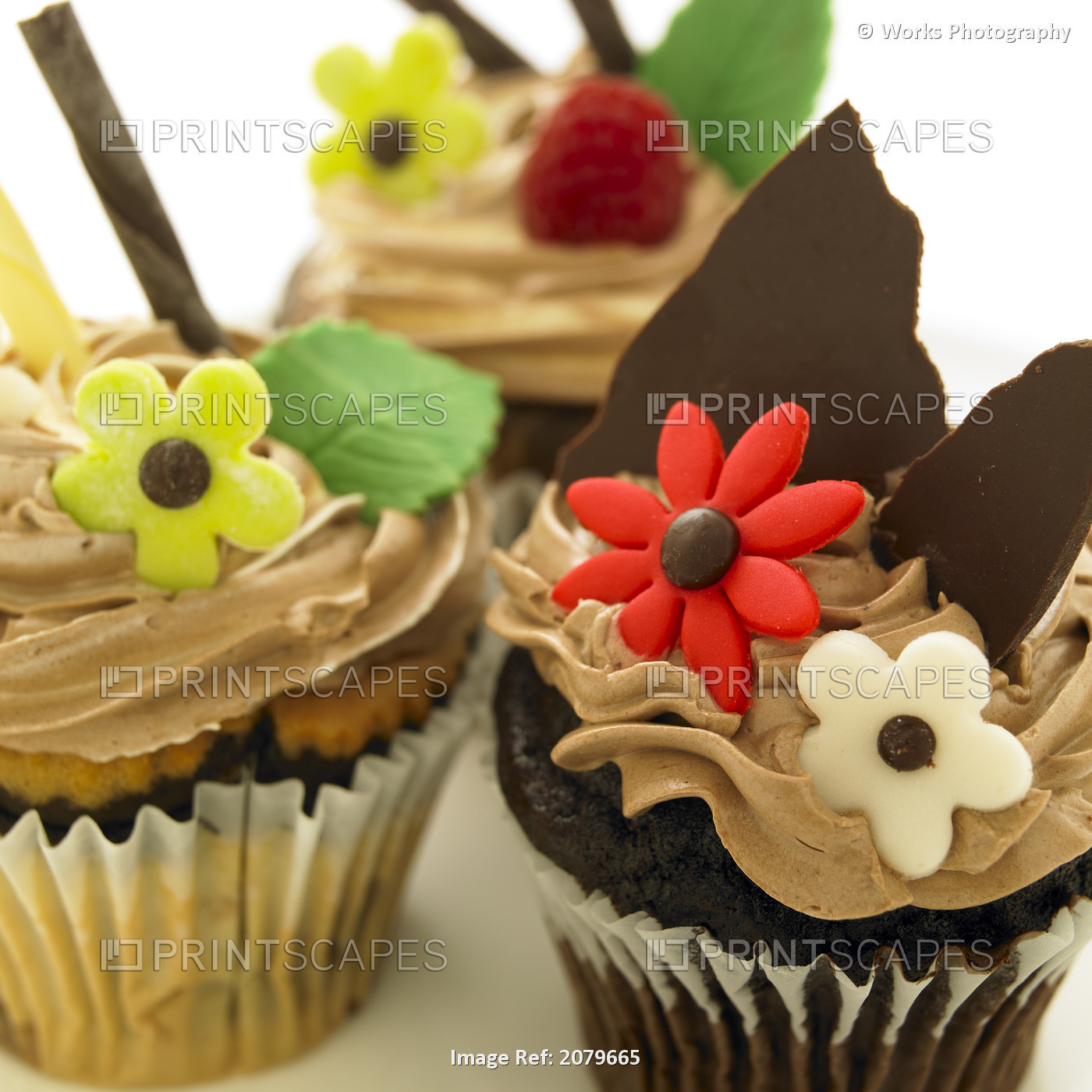 Close-Up Of Three Chocolate Cupcakes With Candy Flowers.