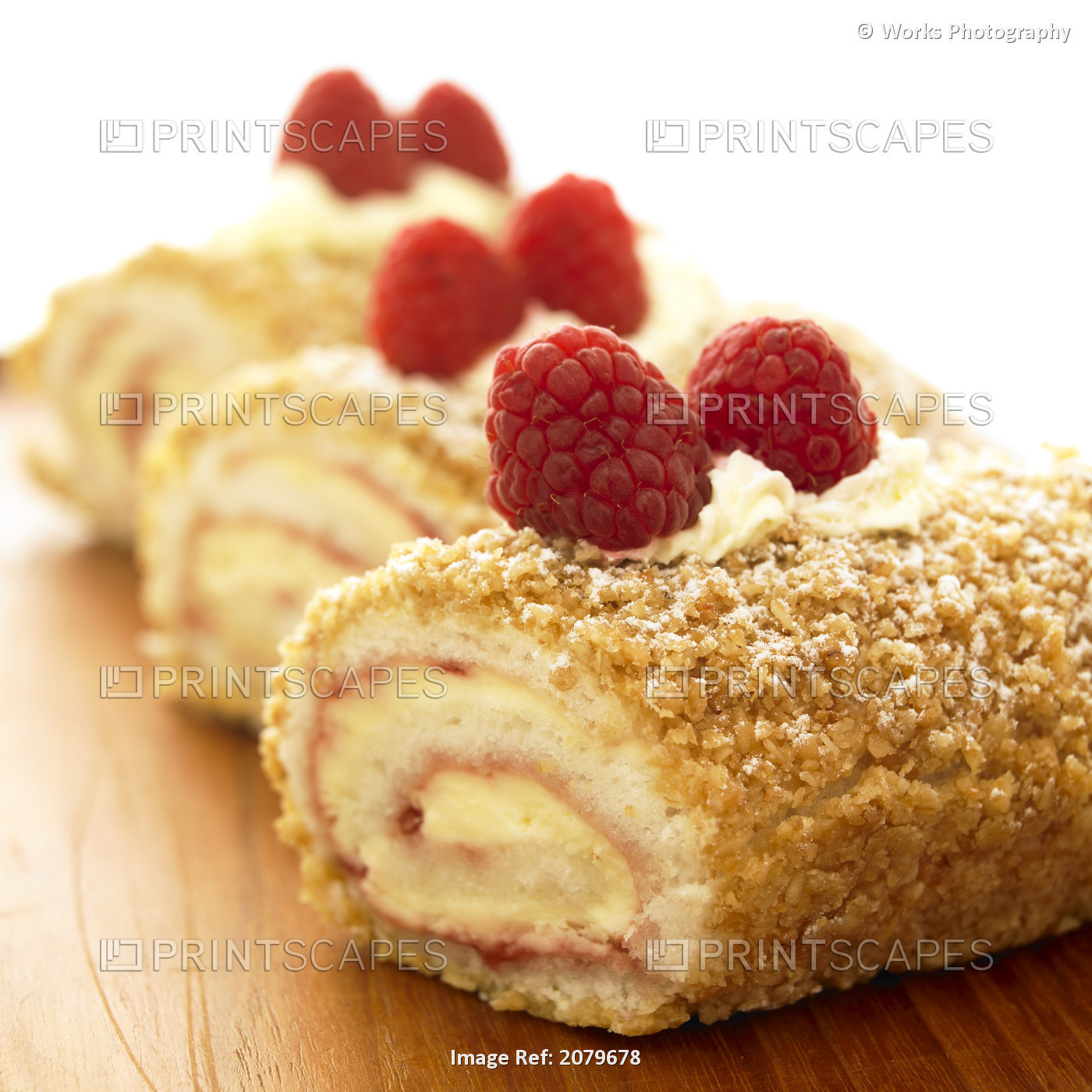 Close-Up Of Three Raspberry Vanilla Jellyrolls With Raspberries On Top.