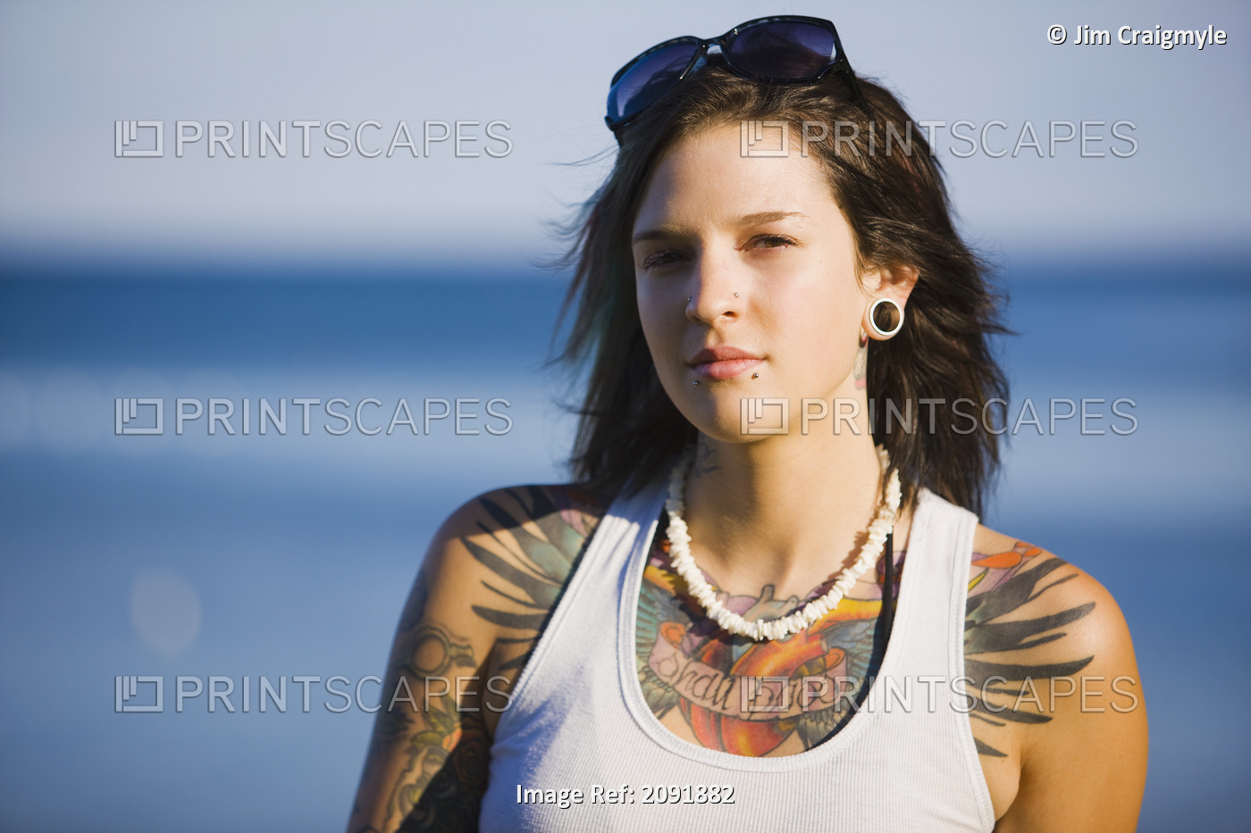 Young Woman With Tattoos Sitting By Lake Simcoe; Ontario Canada