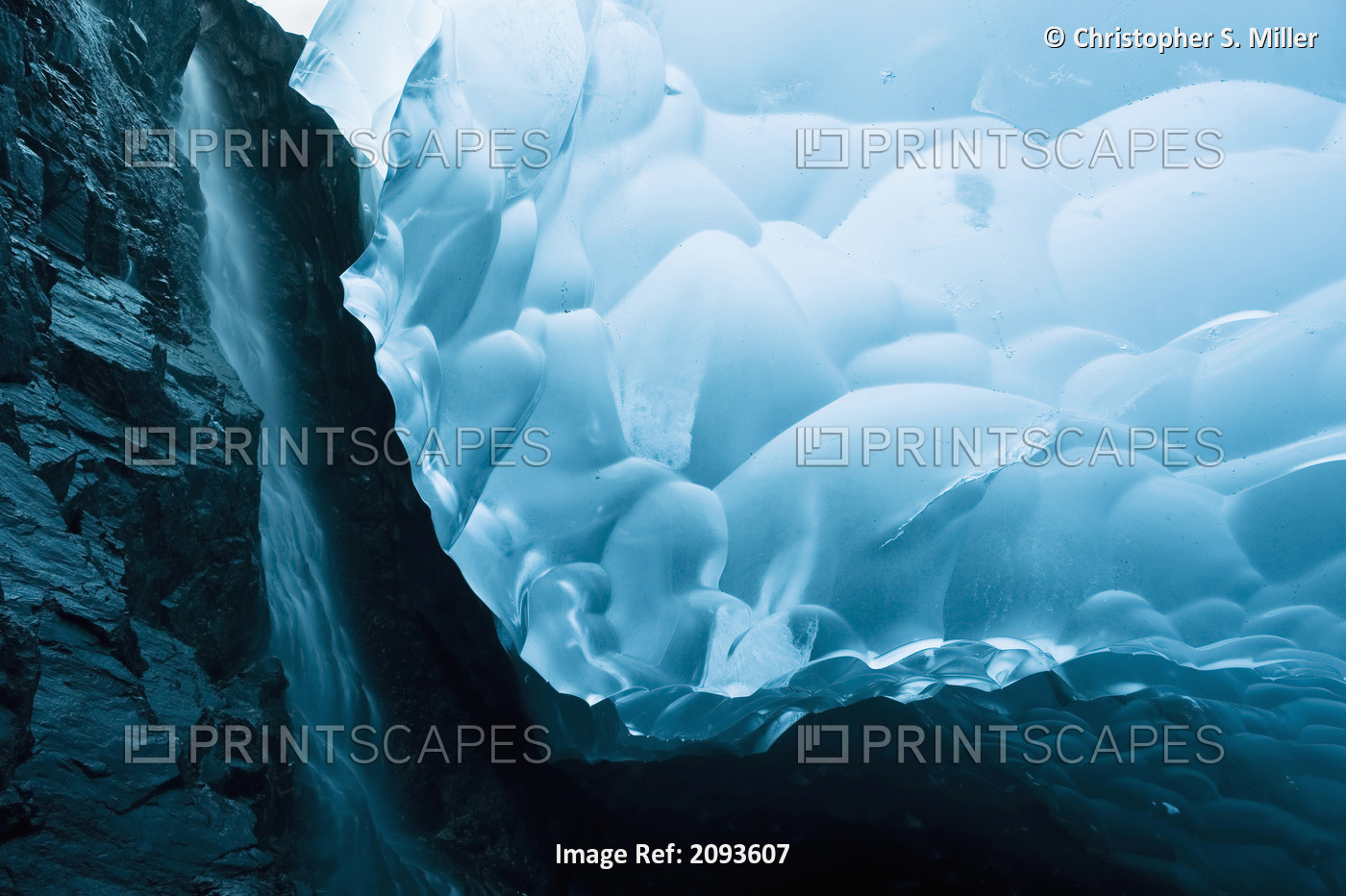 A Waterfall Trickles Its Way Down The Rock Face Of An Ice Cave Inside The ...