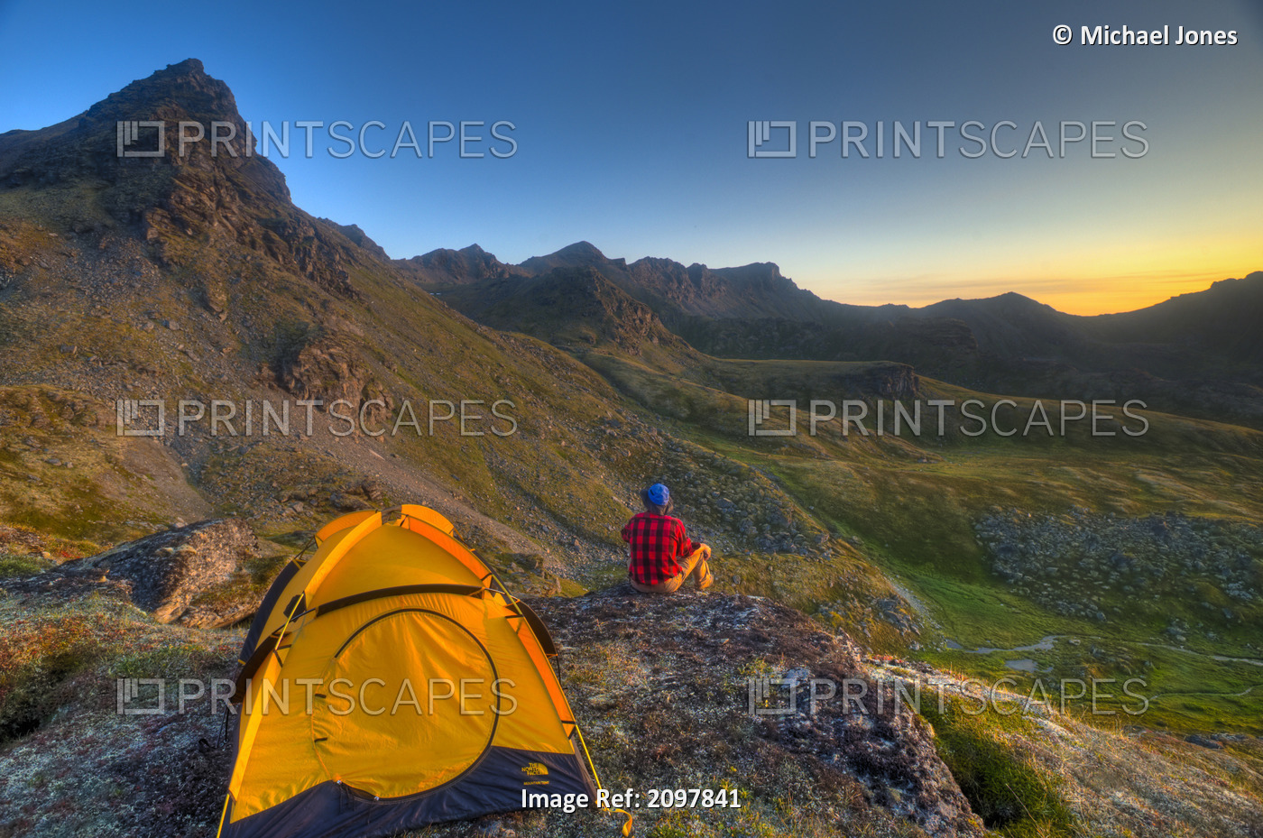 A Man Sitting On A Rock Next To His Tent While Camping Near Hatcher Pass In The ...