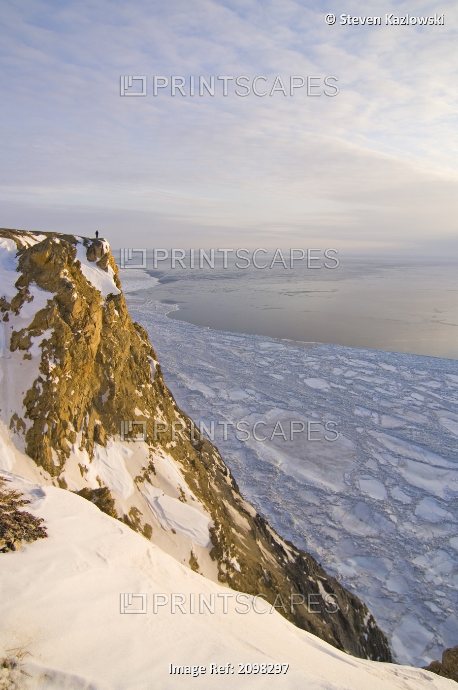 Man On Cliff At Cape Thompson Overlooking Thin Pack Ice On The Chukchi Sea