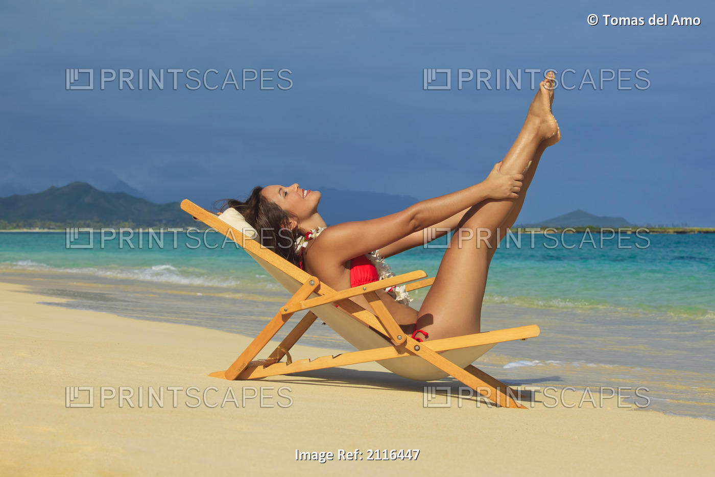 Hawaii, Oahu, Kailua, Lanikai, Beautiful woman stretches in a lounge chair on ...