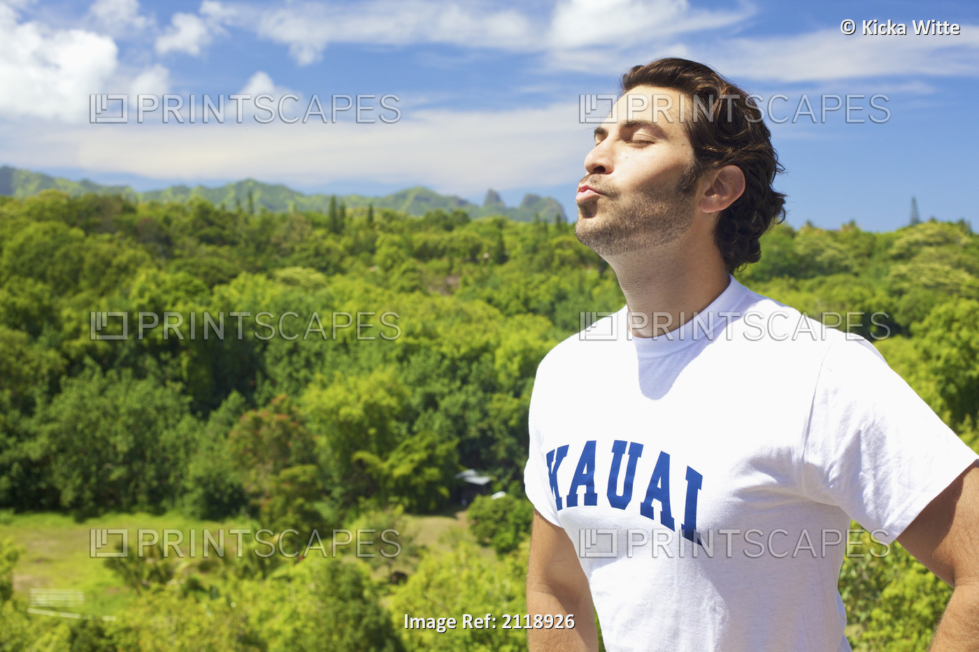 A man puckering his lips as he looks up with the sun shining on his face; ...