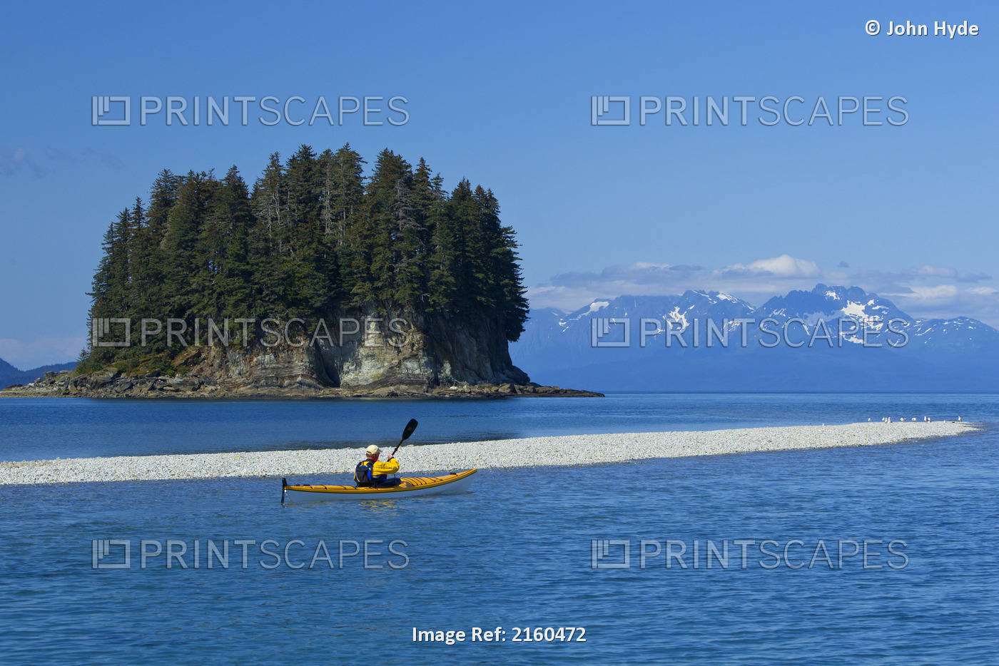 Sea Kayaker Paddles Along The Shoreline Near Juneau With Coast Mountains In The ...