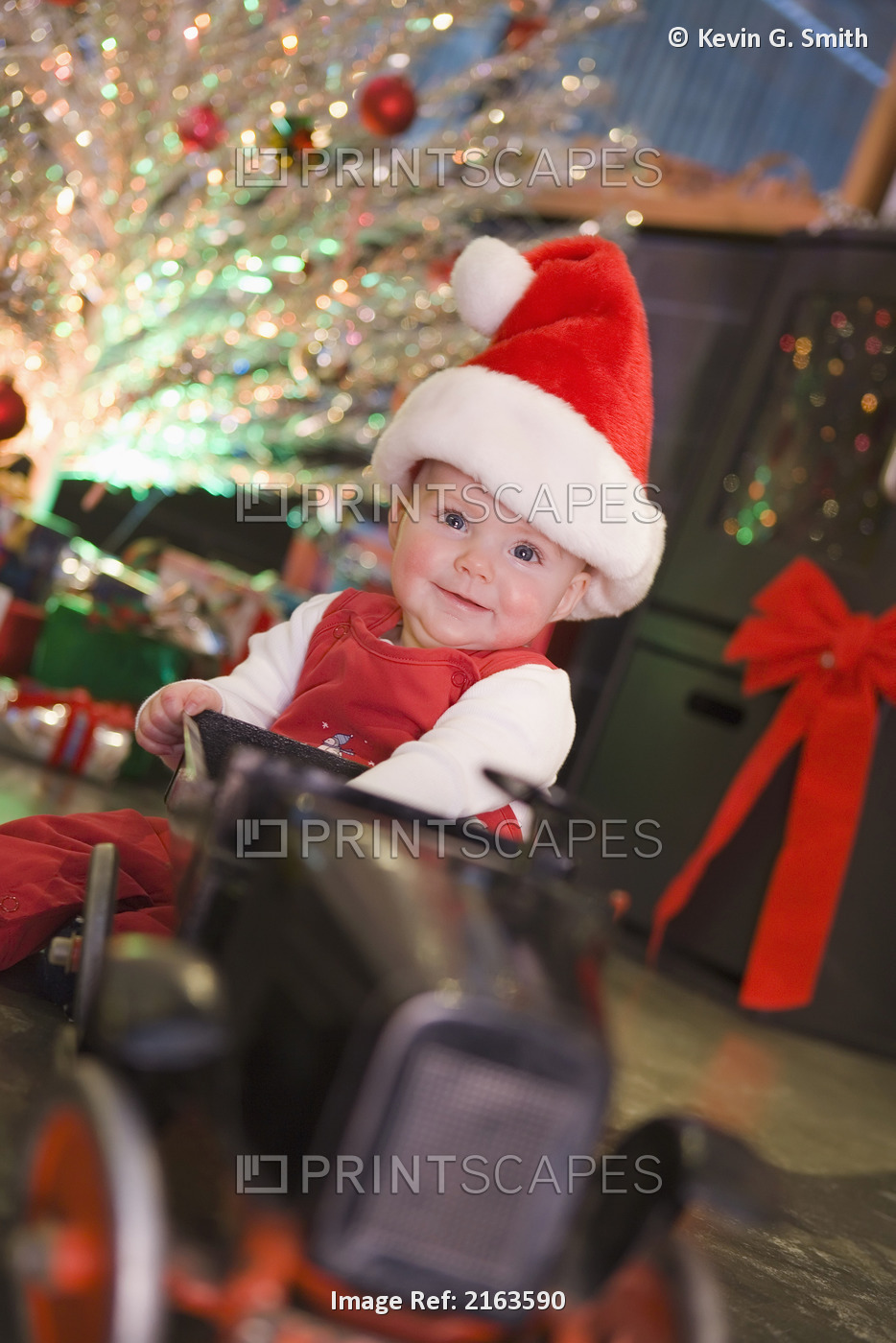 Portrait Of Infant Girl Wearing Santa Claus Hat Sitting In Christmas Decorated ...