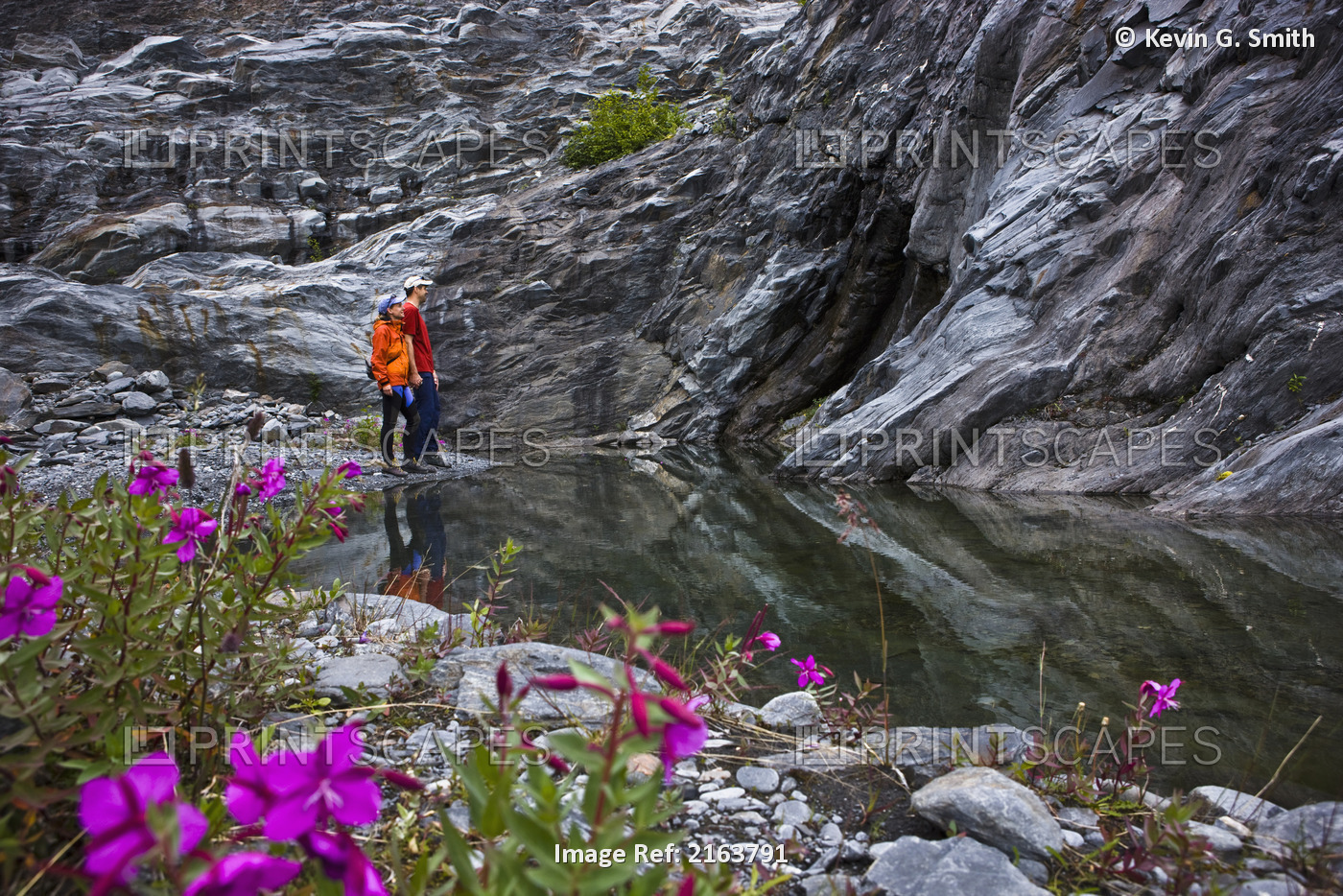 Couple Standing Next To A Glacier Carved Meltwater Pool Recently Exposed By The ...