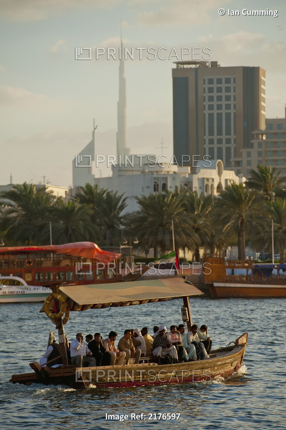 UAE, People on water taxi at dusk at the Creek with the Burj Kalifa; Dubai