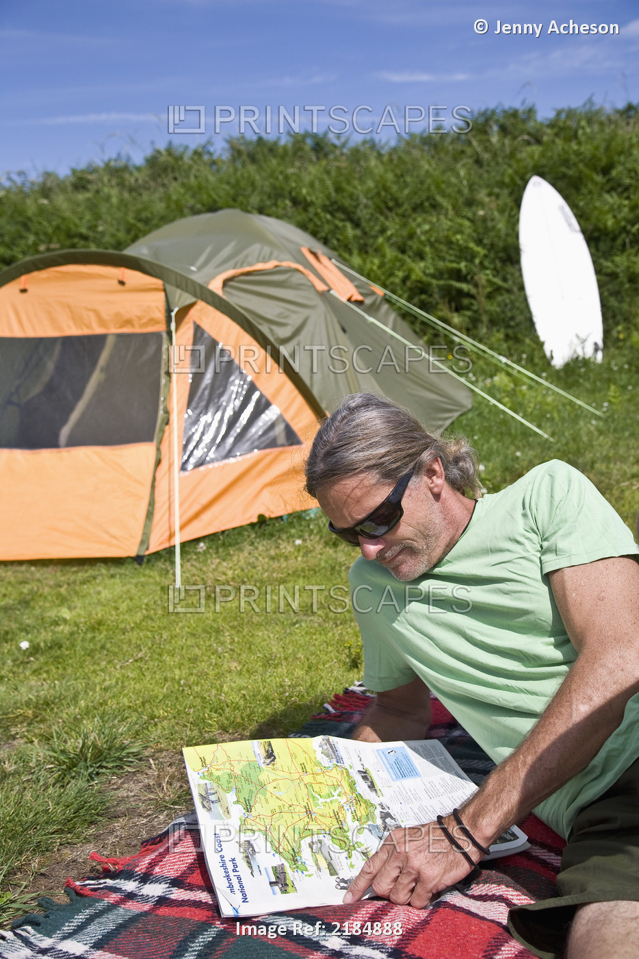 United Kingdom, Wales, Pembrokeshire, Man Reading Map In Front Of His Tent; ...