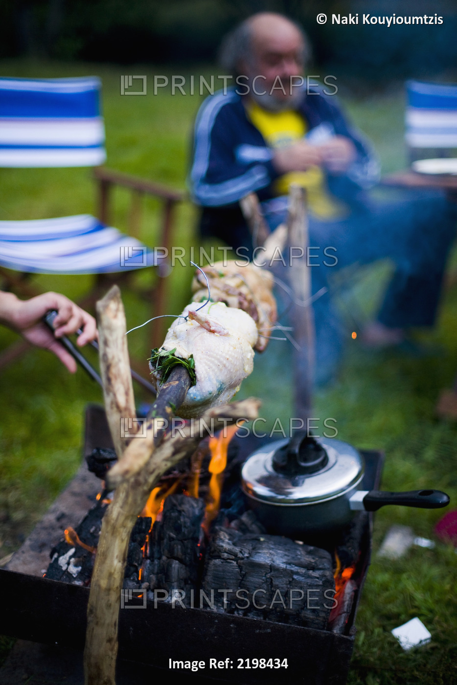 UK, Wales, North Wales, Snowdonia National Park, spit roast chicken over open ...