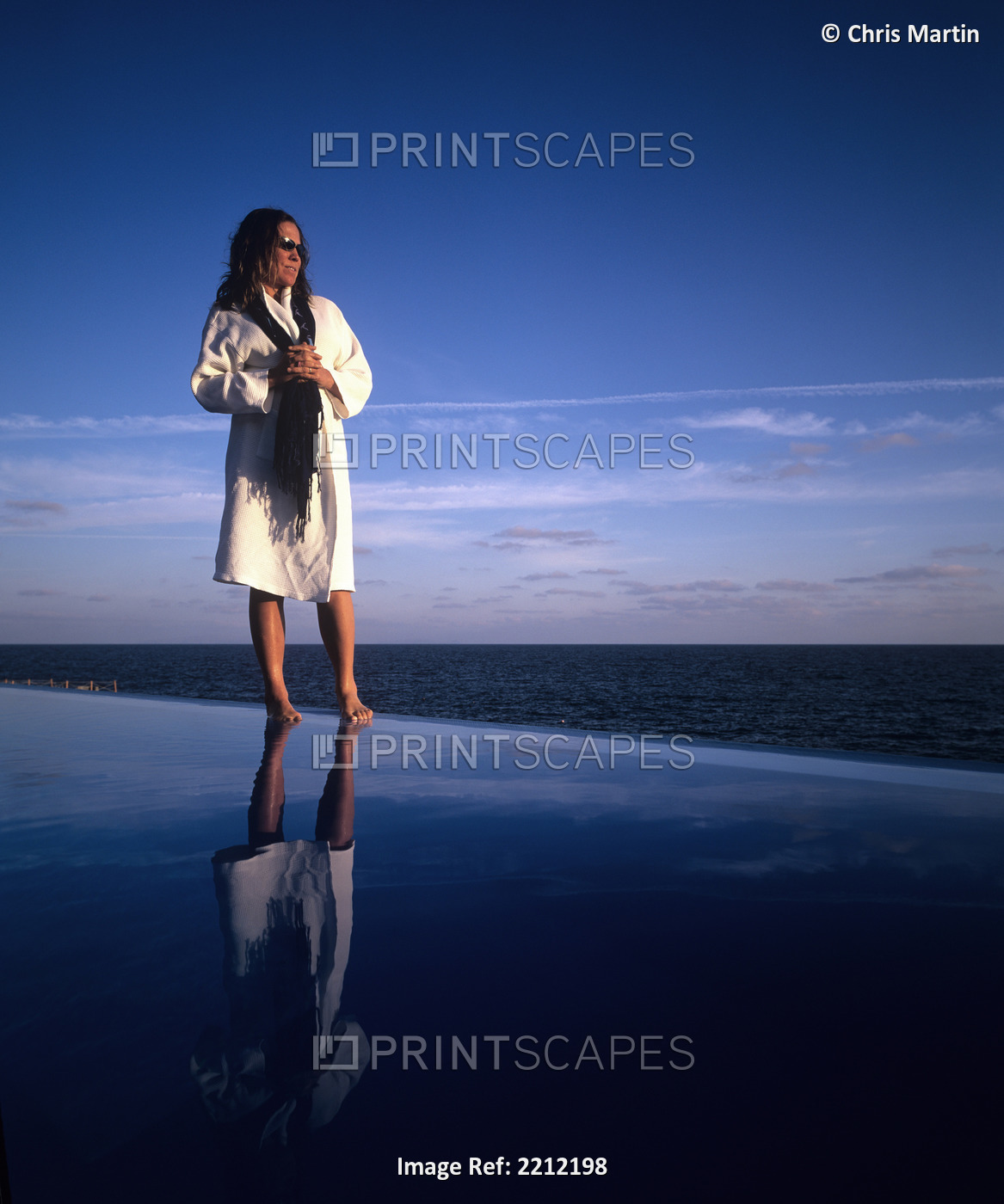 Woman Standing In A Spa Robe On The Edge Of An Infinity Pool Looking Out Over ...