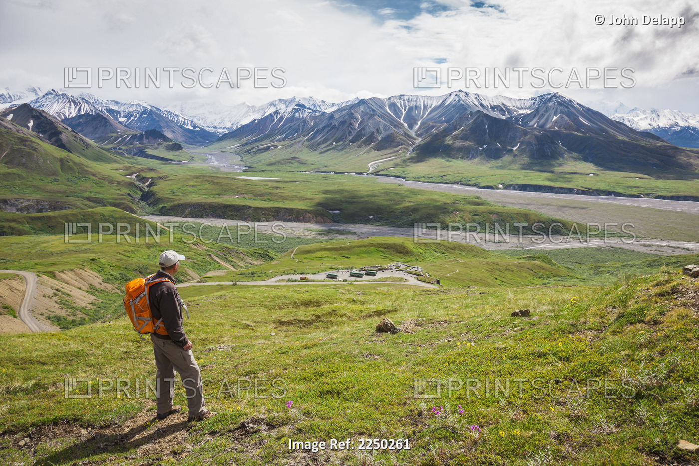 A Senior Male Hiker Stands On The Mountain Side Looking Down At The Eielson ...