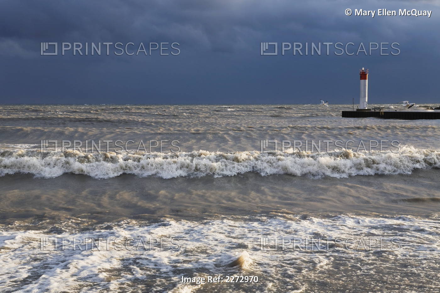 Storm waves crashing on a beach near a lighthouse on lake ontario; whitby ...