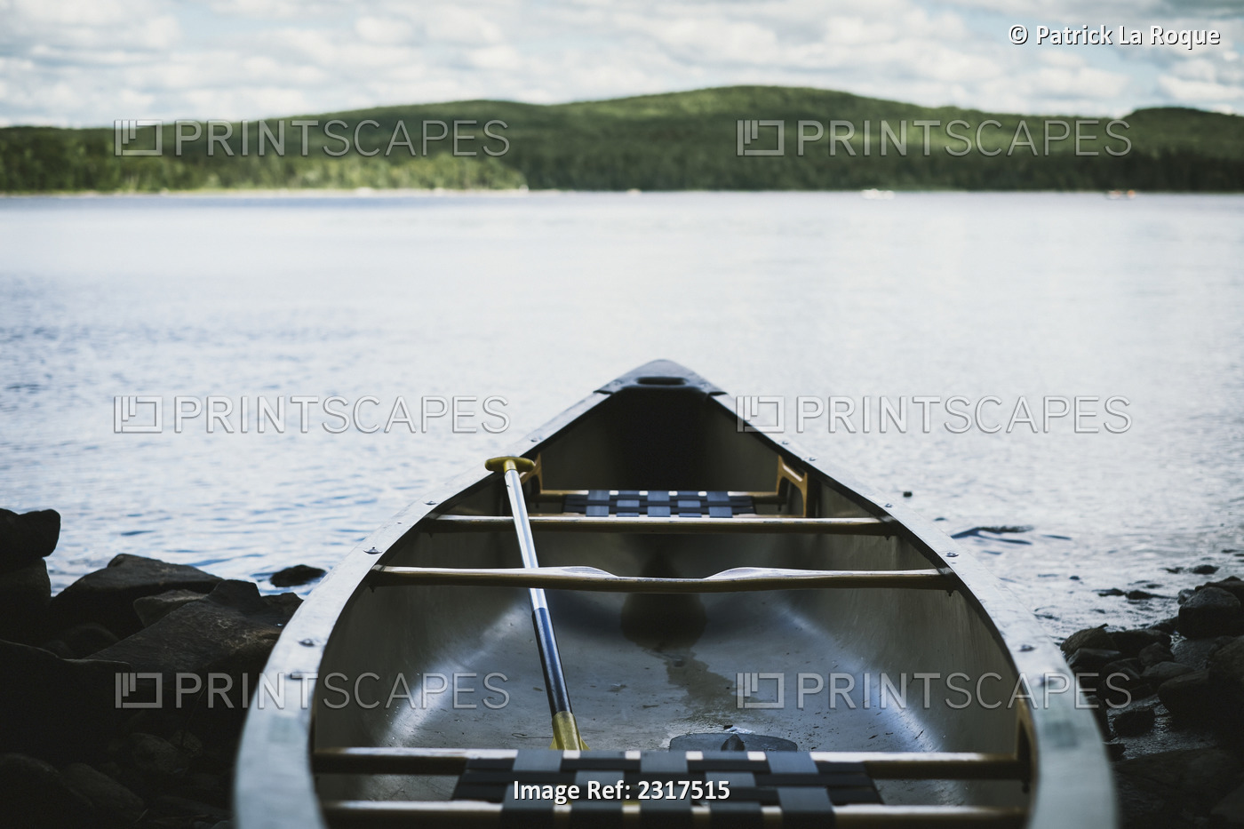 Fiberglass canoe at lakeside with mountain on the horizon; Thetford mines ...