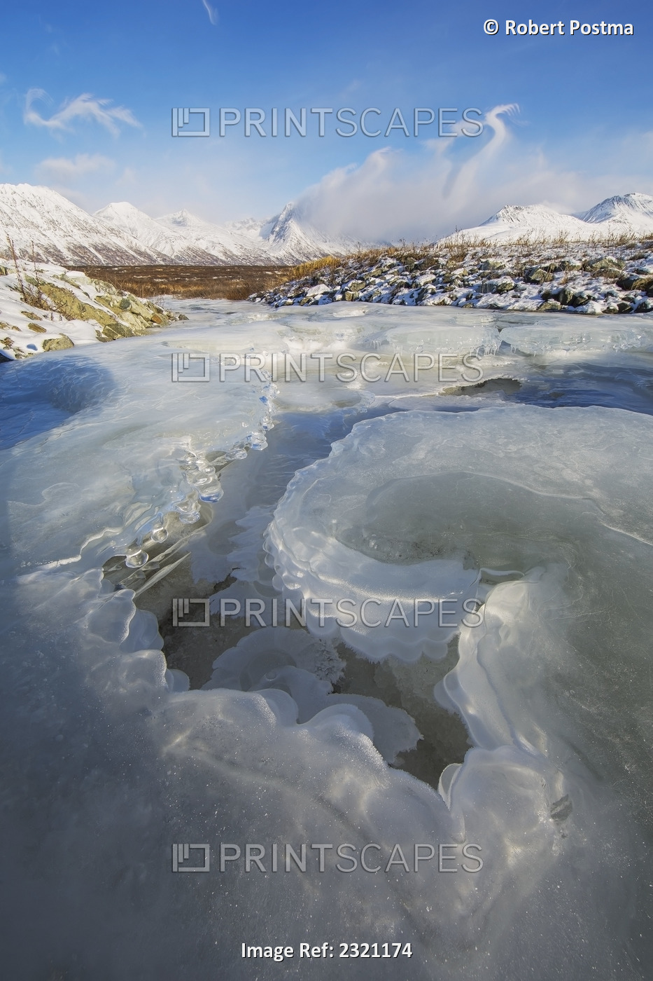 The ice in a stream leading off into a snow covered valley haines highway; ...