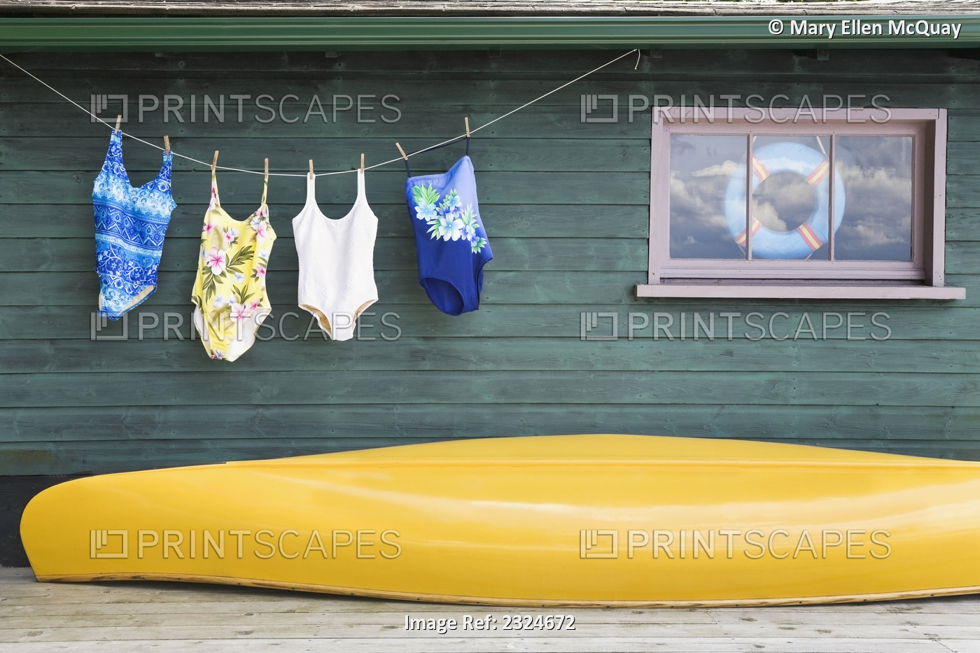 Bathing Suits On Clothes Line With Yellow Canoe Against Cottage, Ontario, Canada