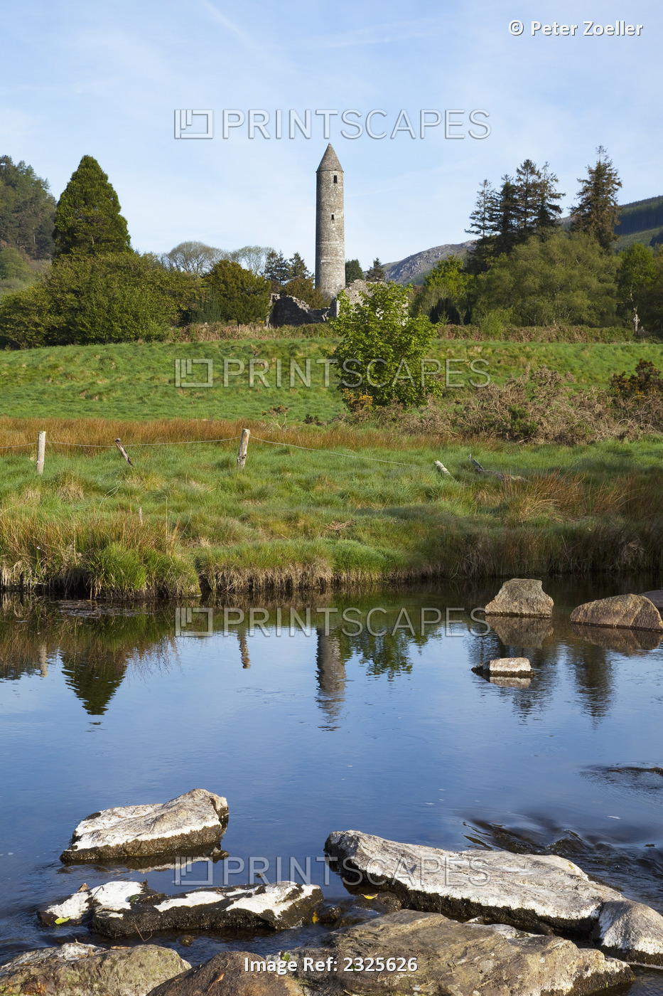 A round tower with the reflection in a tranquil pond in the foreground; ...