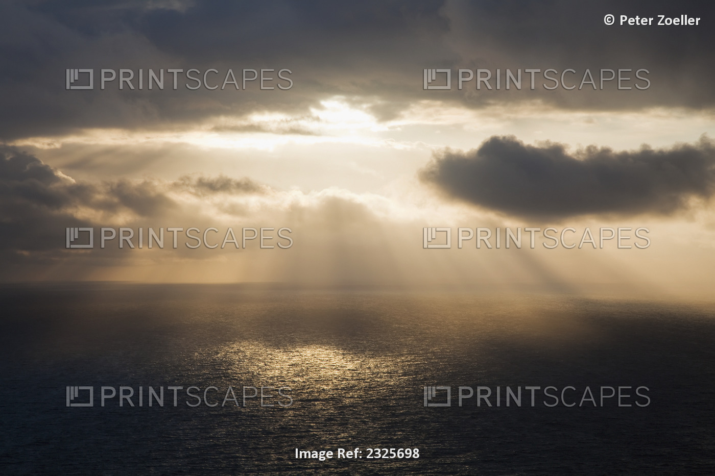 Sunlight streaming through the dark clouds and reflecting on the ocean; County ...
