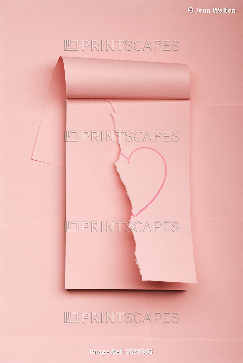 Notepad with drawn heart ripped in half