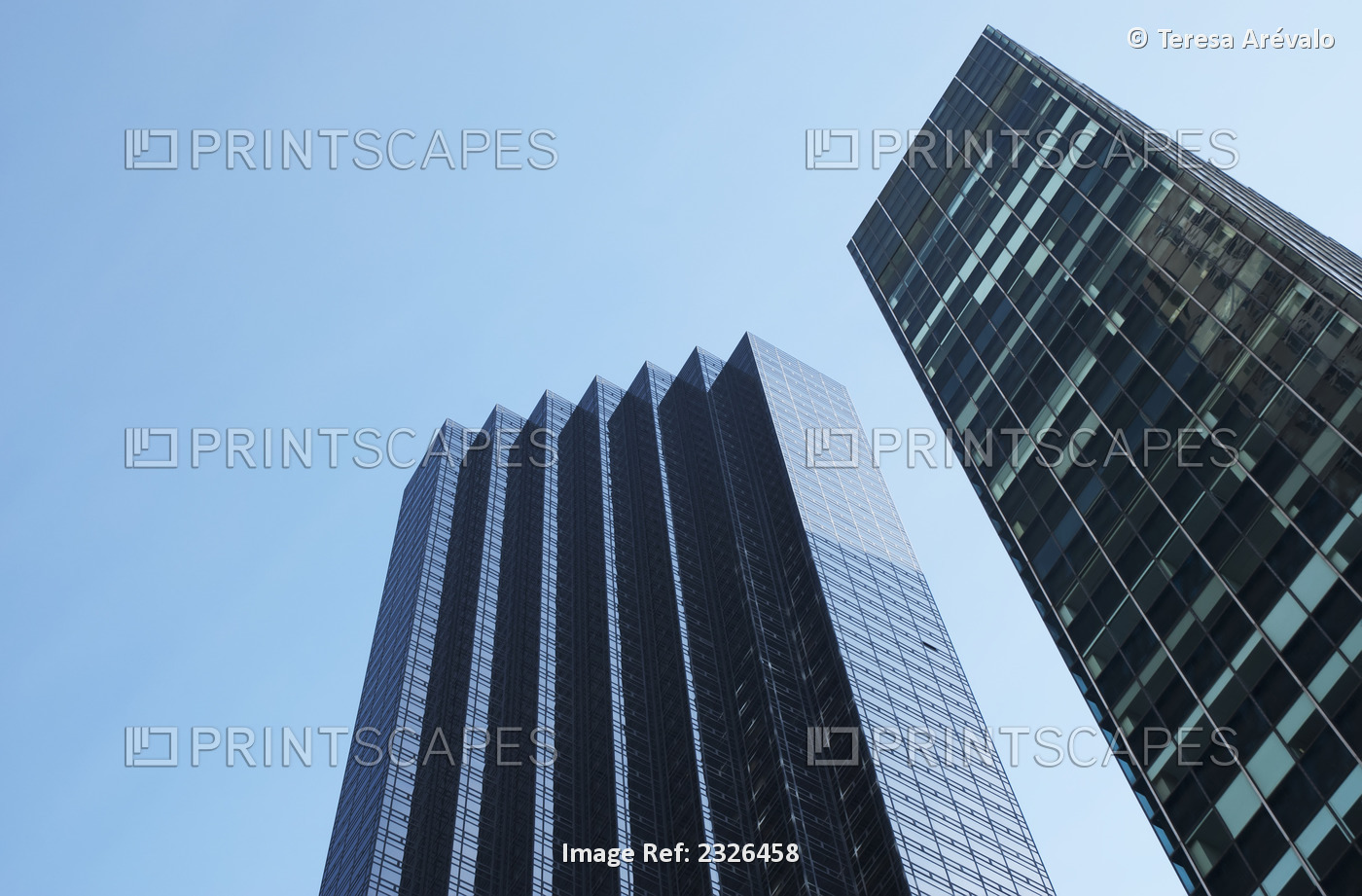 Low angle view of two skyscrapers against a blue sky with a facade like steps; ...