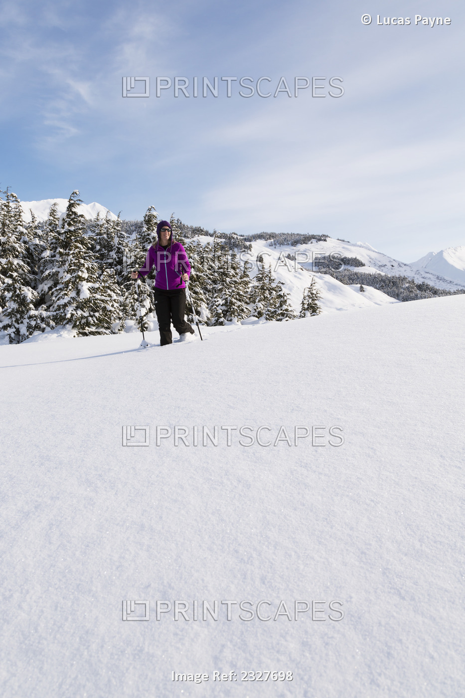 Woman snowshoeing on a sunny day at Turnagain Pass, Kenai Peninsula, Chugach ...