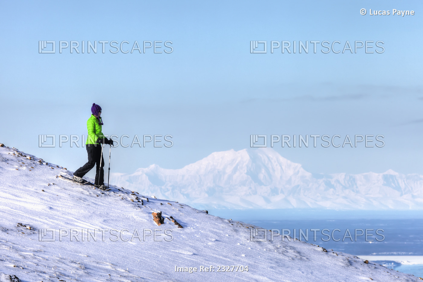 Woman snowshoeing on Blueberry Hill at the Glen Alps area of Chugach State Park ...
