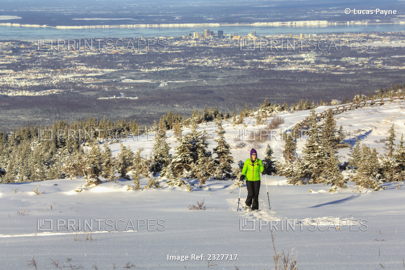Woman snowshoeing at the Glen Alps area of Chugach State Park overlooking ...