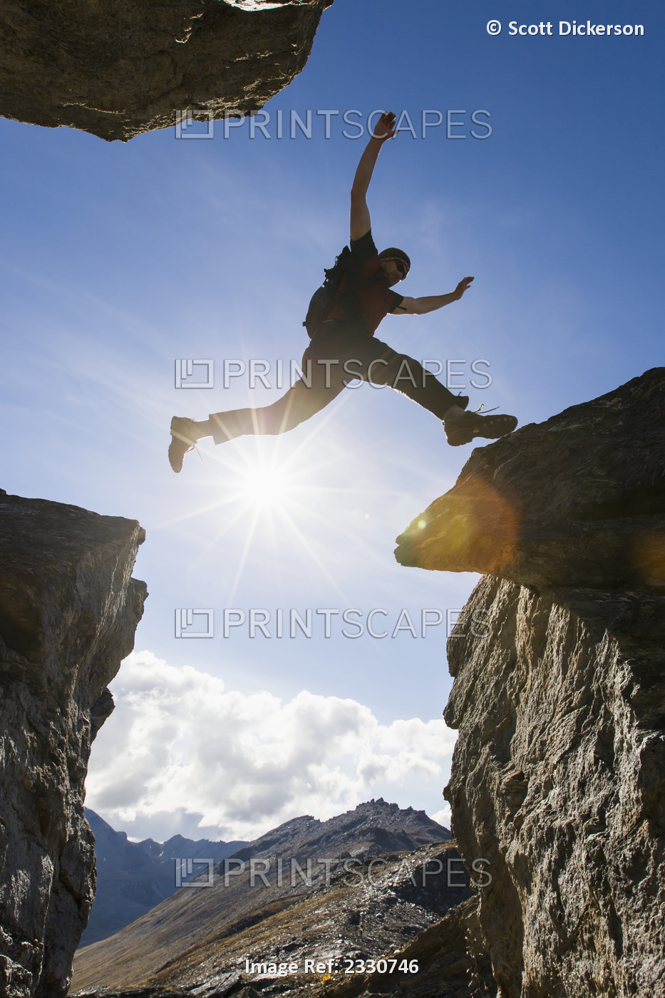 Backlit View Of Hiker Leaping Between Rocks Near Noatak River In The Brooks ...