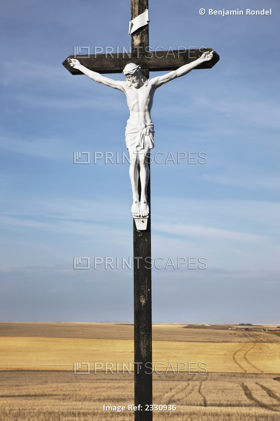 Crucifix and a farm field in the background;Saskatchewan canada