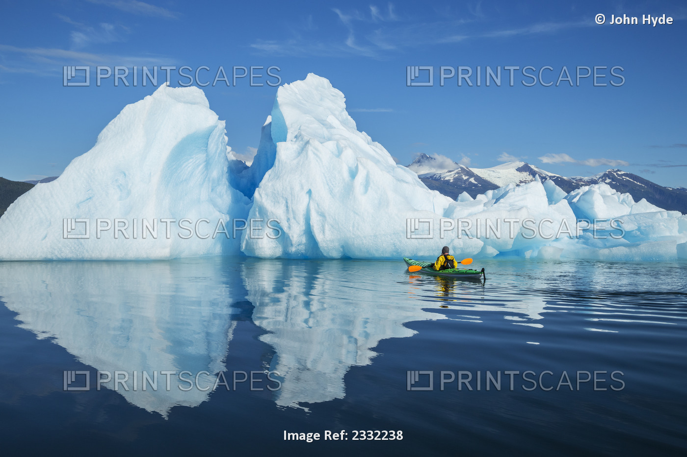 A Sea Kayaker Paddles Beside An Iceberg In Southeast Alaska's Stephens Passage ...