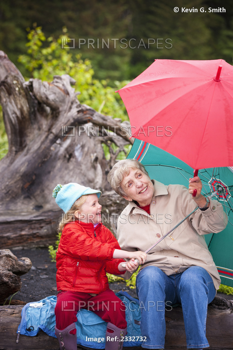 Grandmother And Granddaughter Playing With Their Umbrella While Sitting On A ...