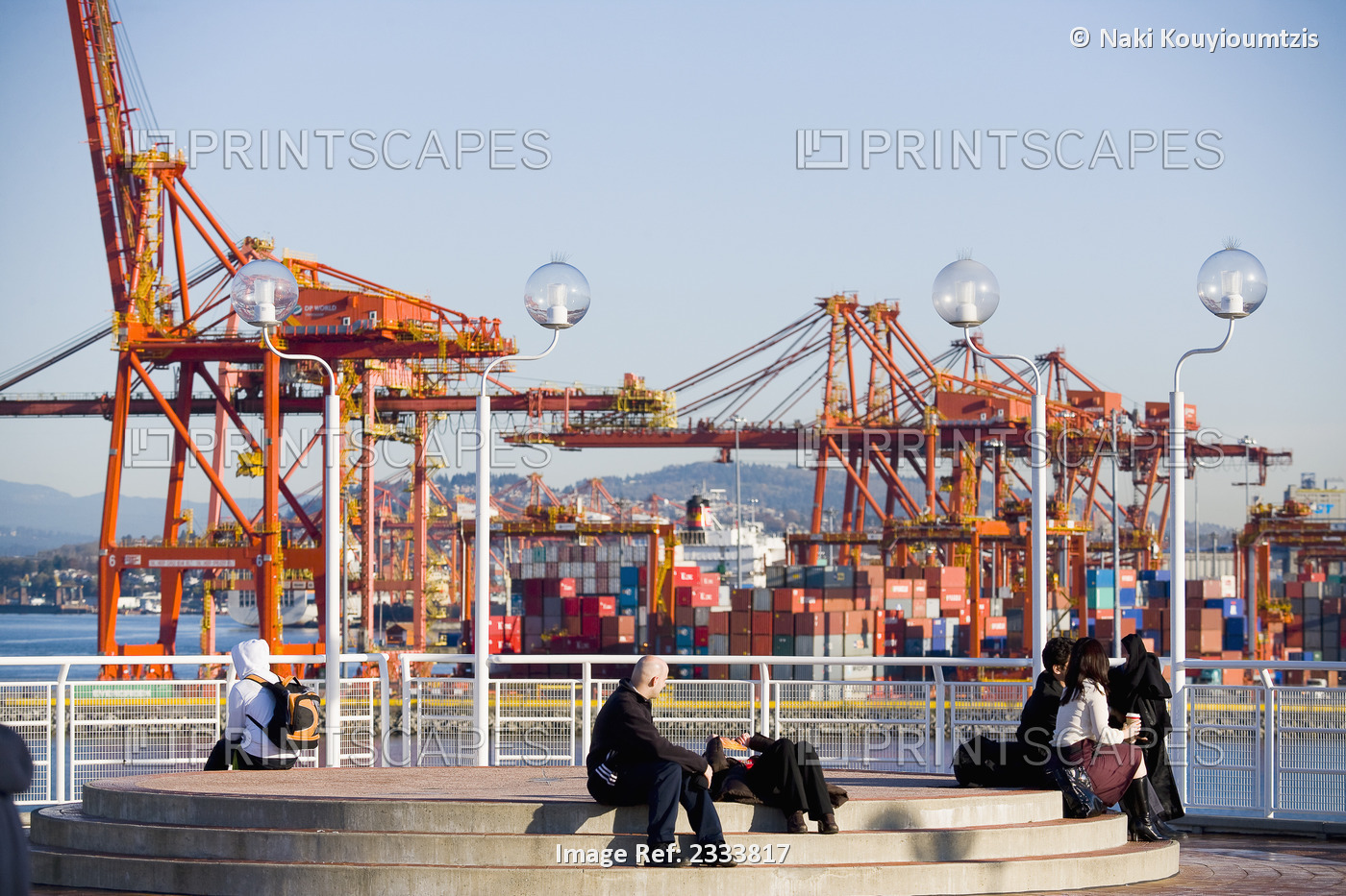 People Sitting With Crane In Background, Vancouver Waterfront, Harbor; ...
