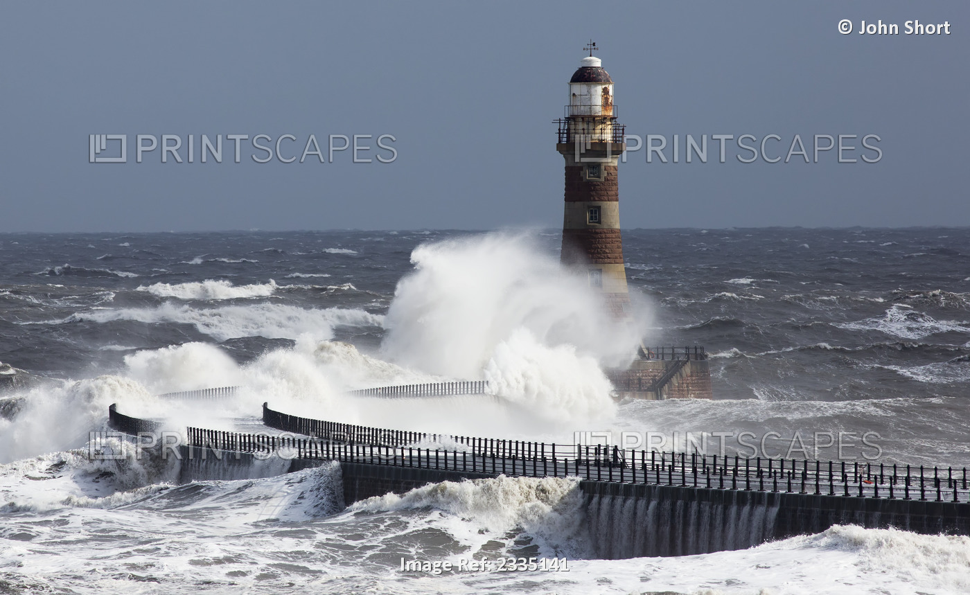 Waves crashing into a lighthouse on the coast;Sunderland Tyne and Wear England