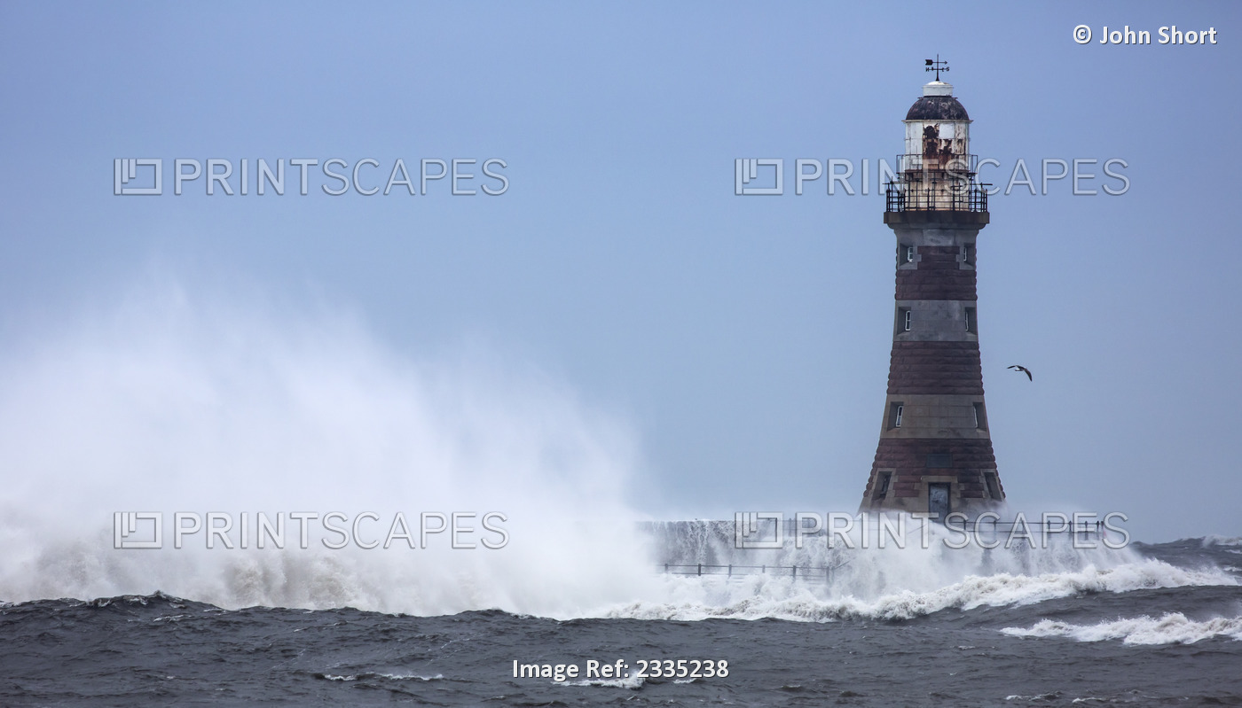 Splashing water from a crashing wave against a lighthouse;Sunderland Tyne and ...