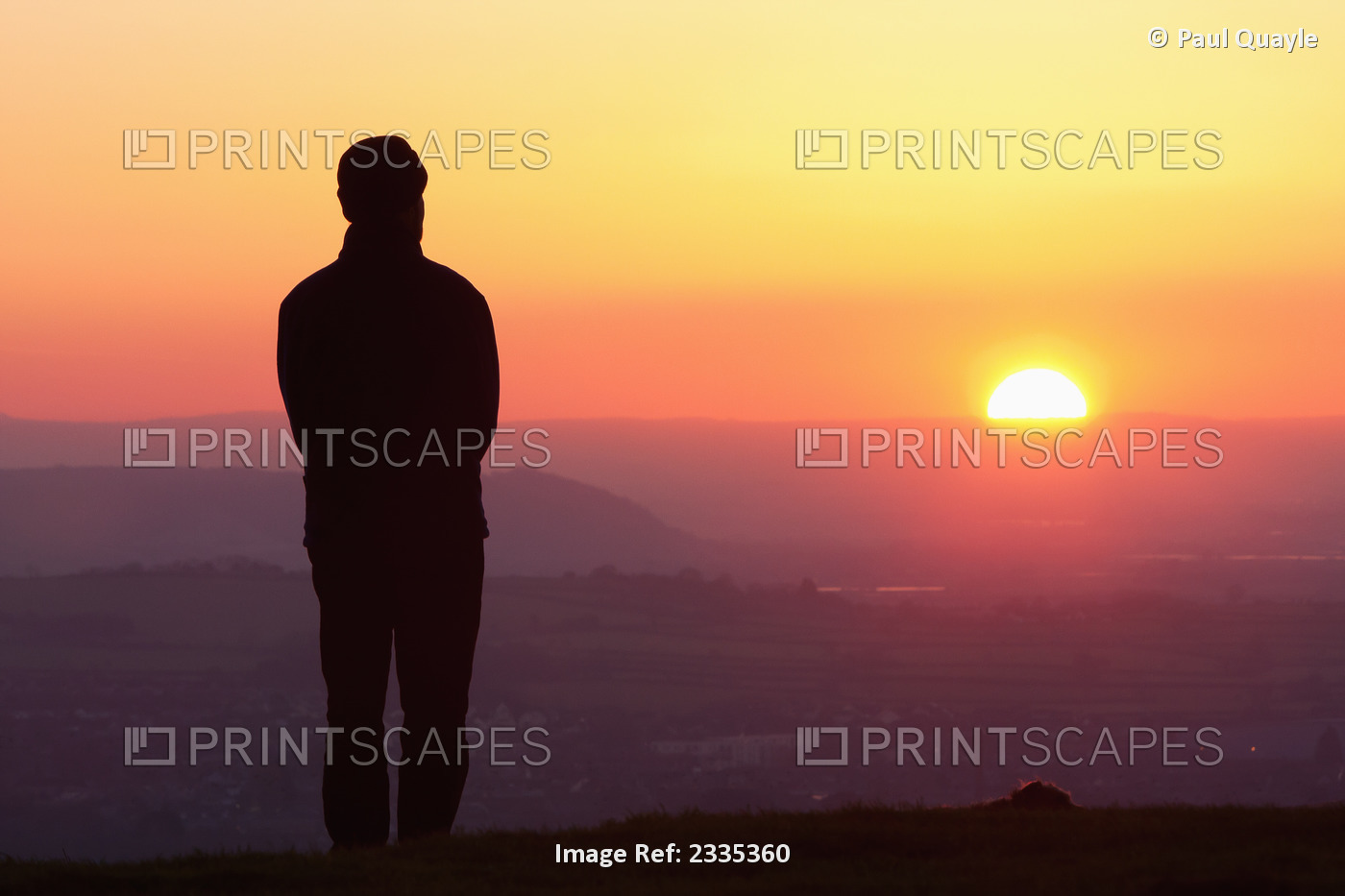 Silhouette Of Man Standing On Glastonbury Tor At Sunset; Glastonbury, Somerset, ...