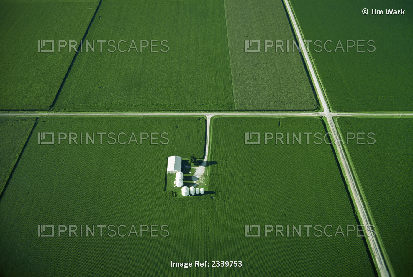Agriculture - Aerial view of cultivated agricultural fields divided by roads, ...