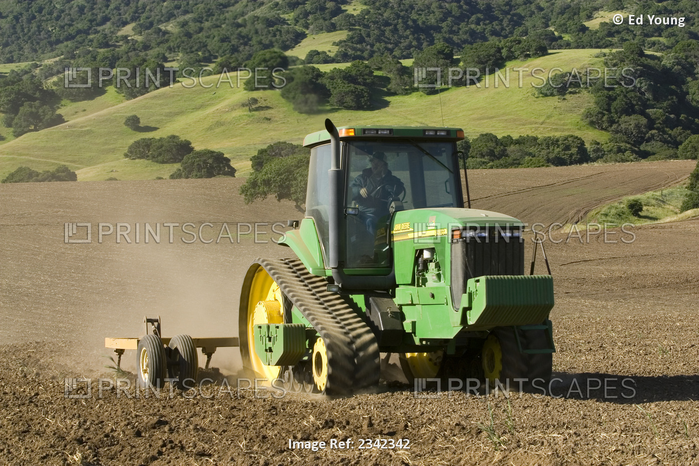 Agriculture - A John Deere tracked tractor and field implement till a new field ...