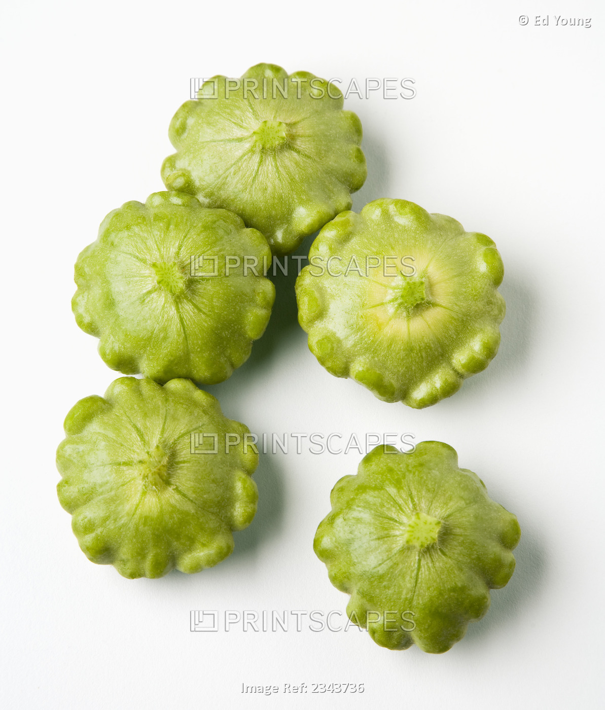 Agriculture - Green pattypan squash on a white surface.