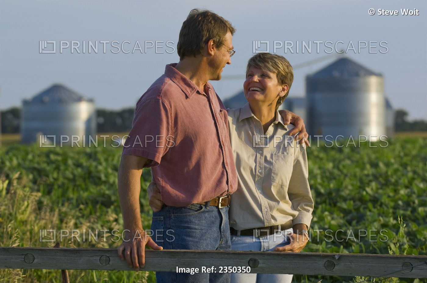 Agriculture - Husband and wife farmers in their mid growth soybean field share ...