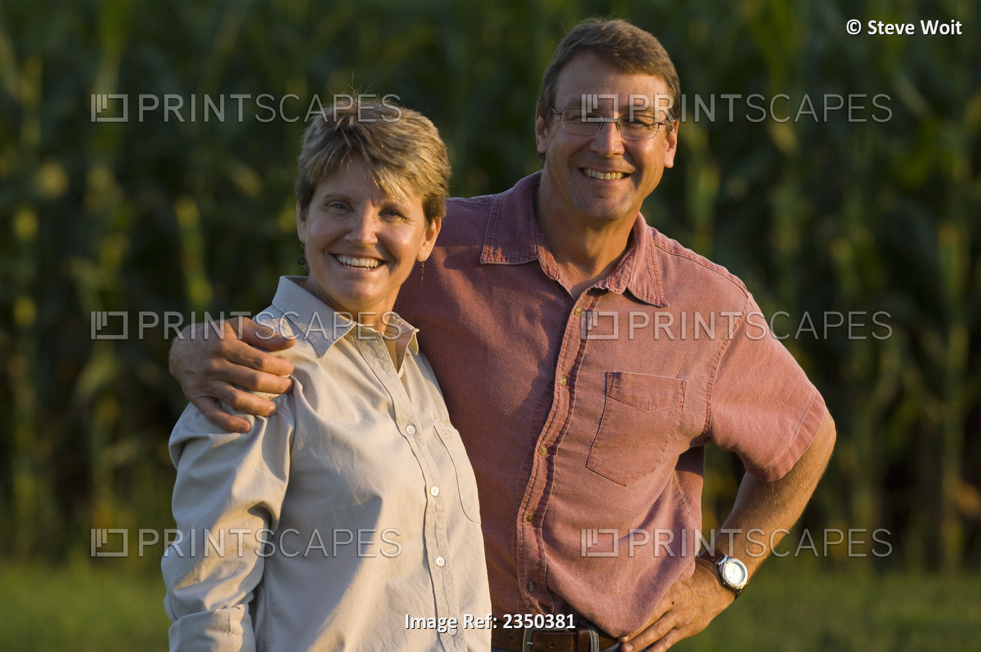 Agriculture - Husband and wife farmers pose together with their maturing grain ...