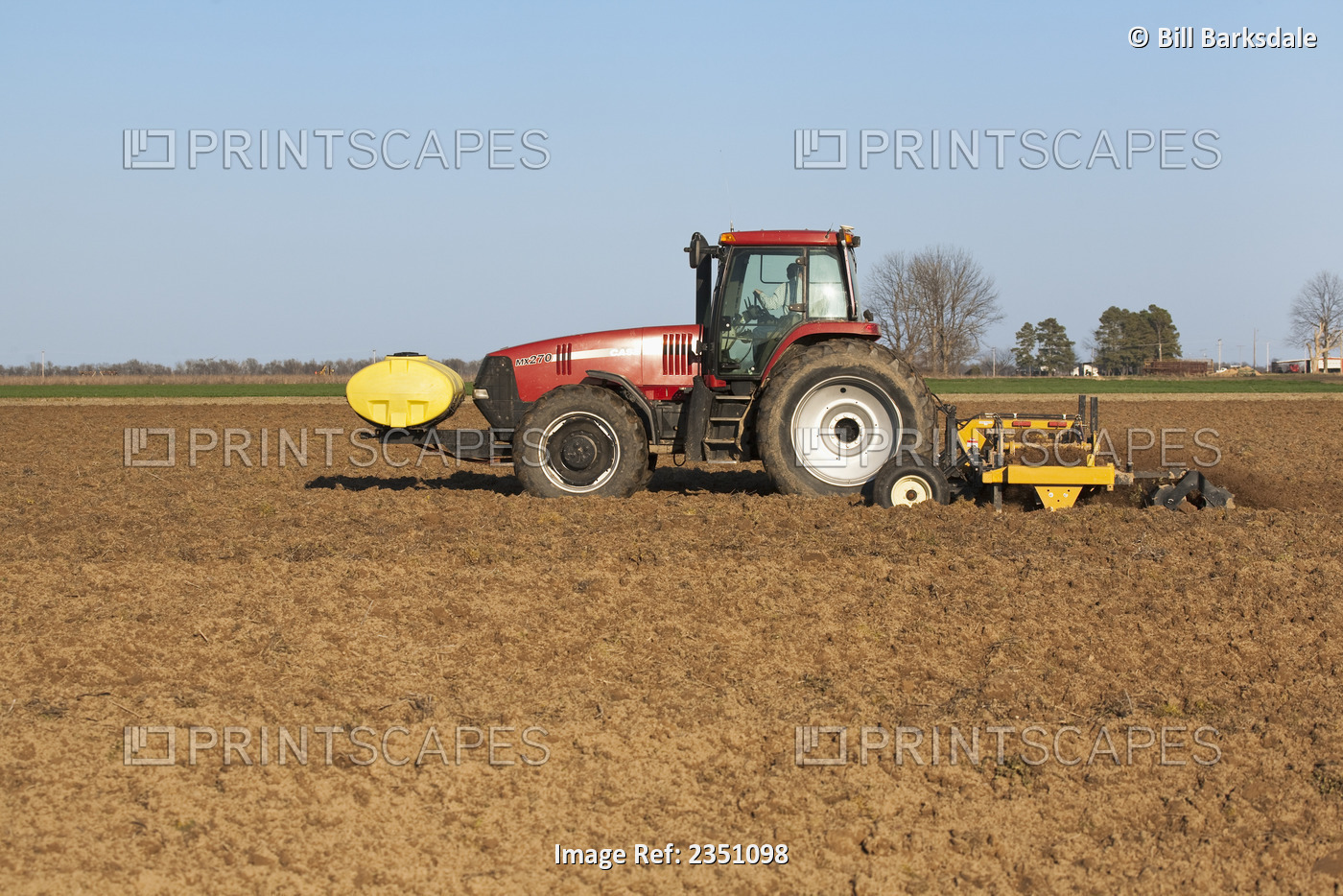 Agriculture - A Case IH tractor and field implement finish soil preparation of ...