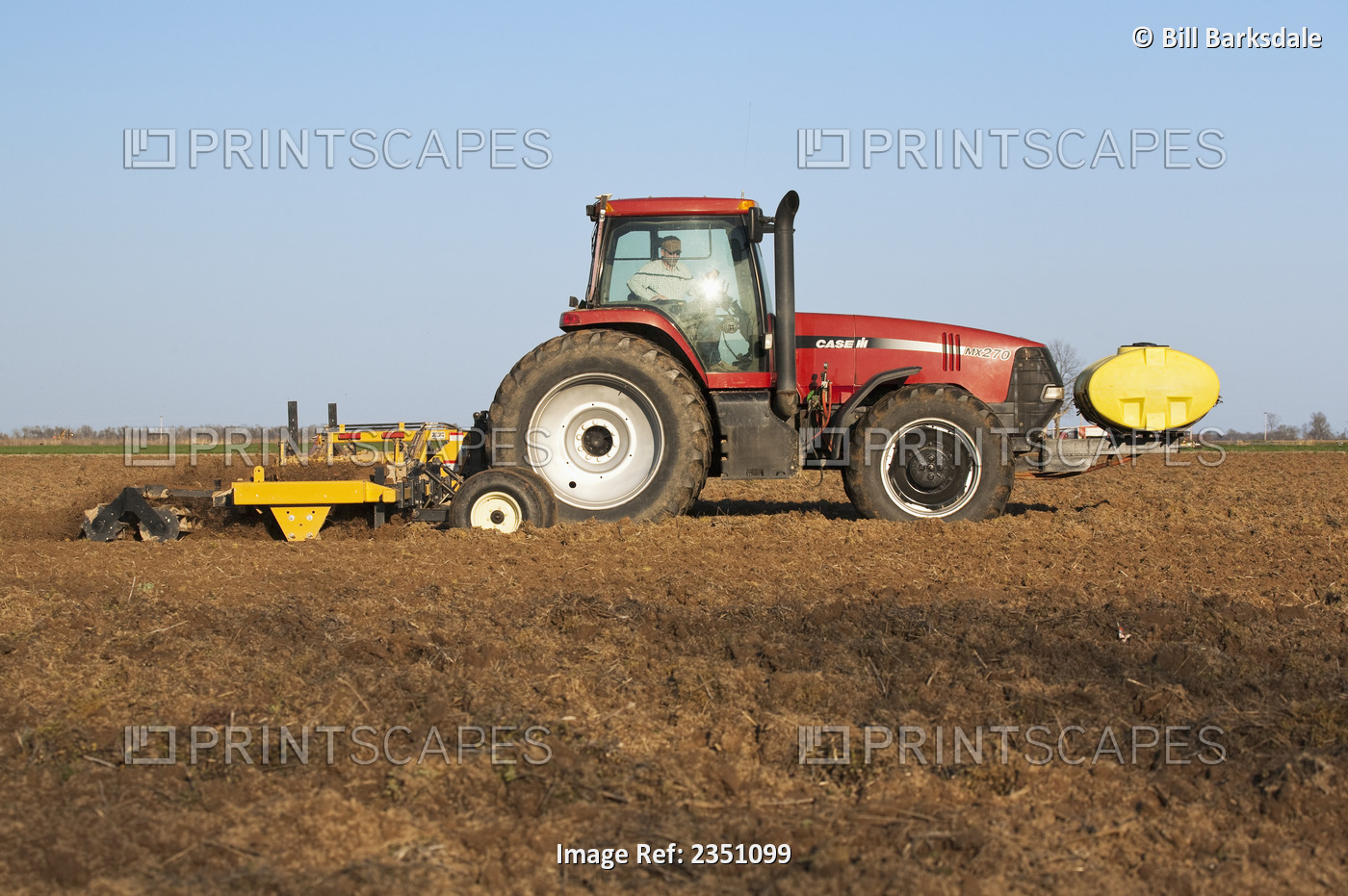 Agriculture - A Case IH tractor and field implement finish soil preparation of ...