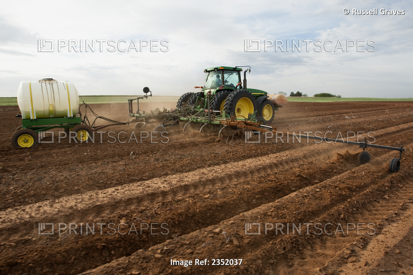 Agriculture - John Deere tractor pulling a field implement preparing a field ...