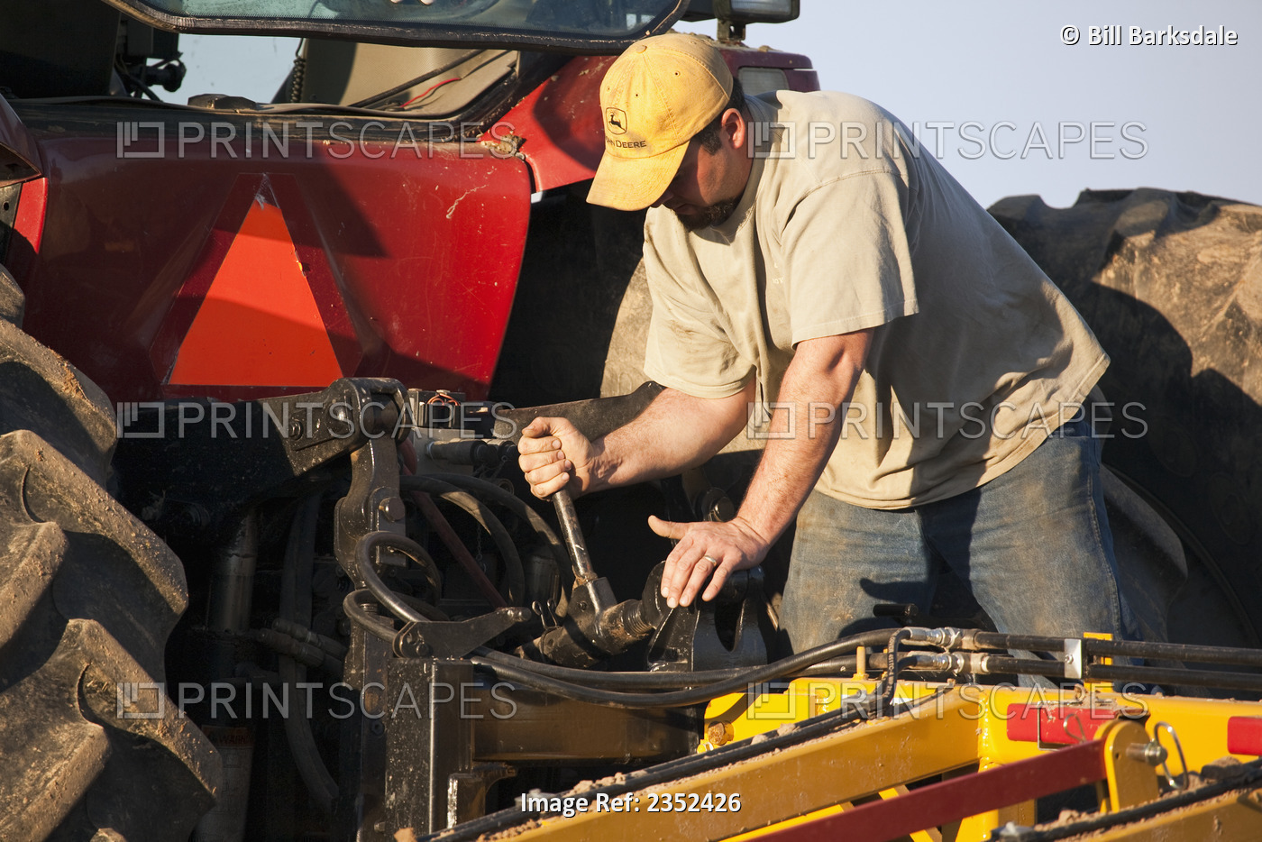 Agriculture - A farmer works to set up a secondary tillage implement during ...