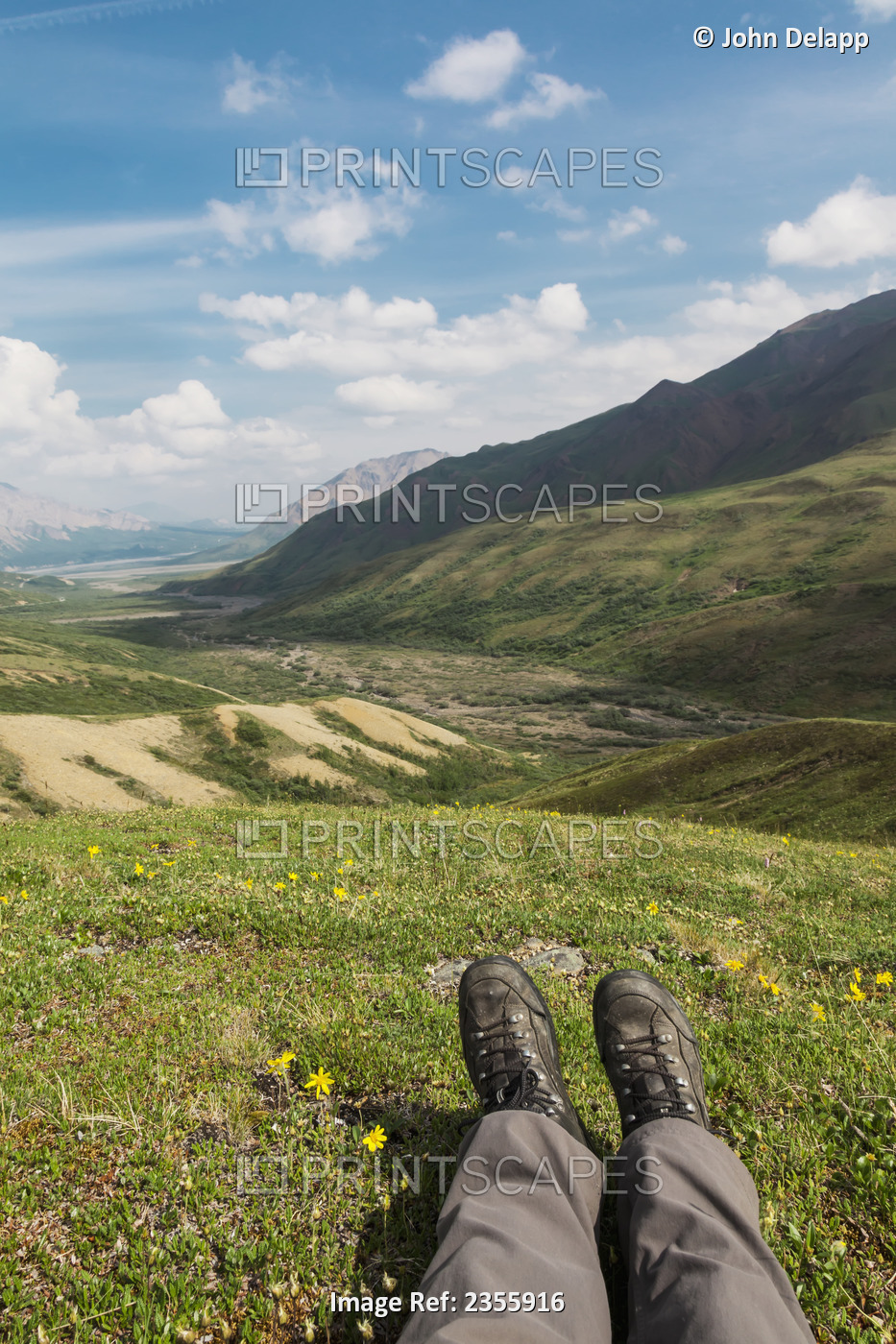 A Hiker's Boots And Lower Legs Appear In The Foreground Of A Mountain Scenic ...