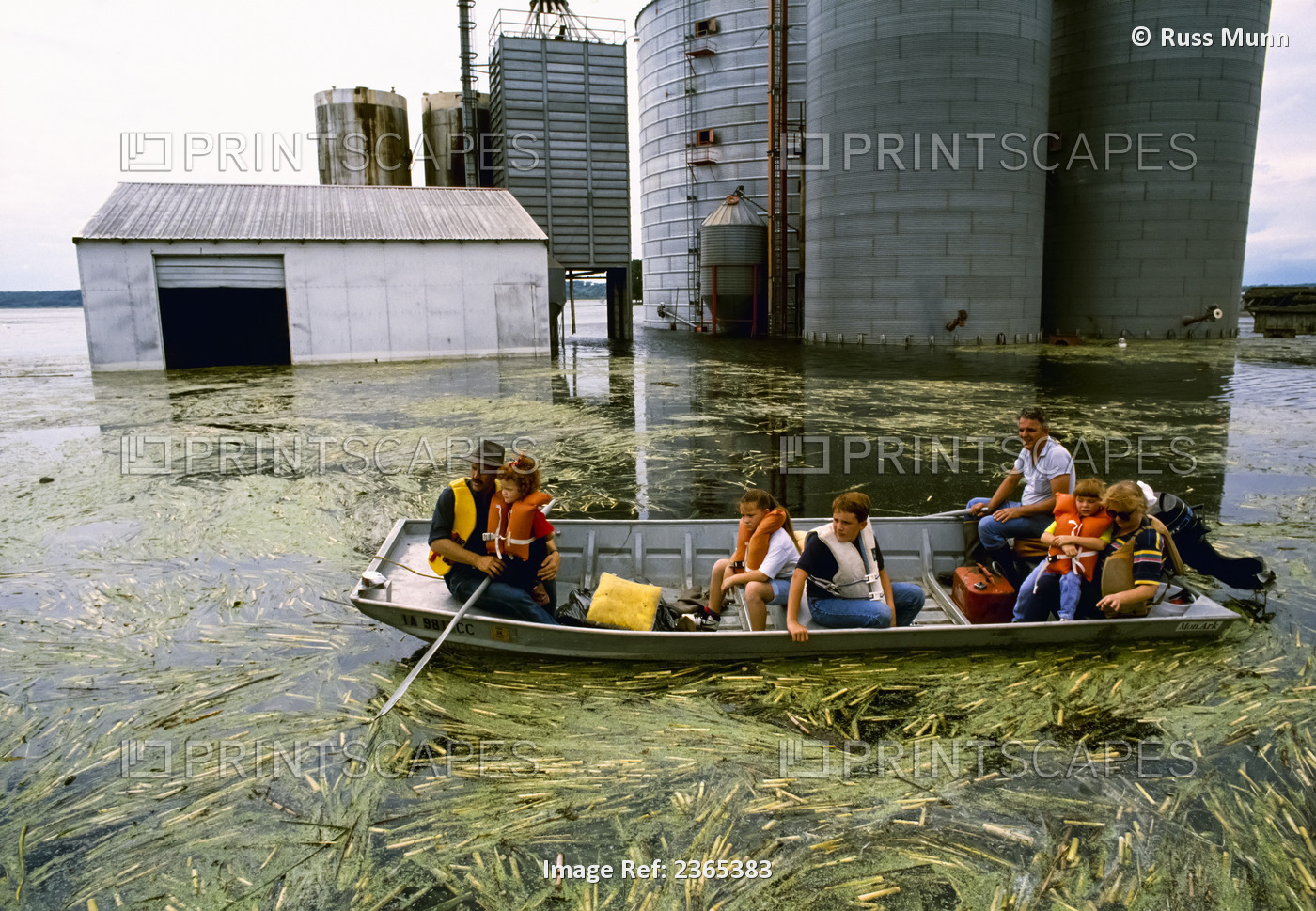 Agriculture - Natural Disaster, Farm family in a skiff surveying their flooded ...